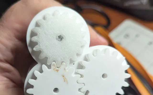 Three 3D-printed spur gears of the main brush gearbox, one printed in POM